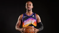 Chris Paul na camisa "The Valley" do Phoenix Suns, segurando uma bola de basquete contra um fundo preto.