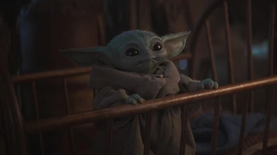 Bébé Yoda dans un berceau confortable, regardant avec curiosité.