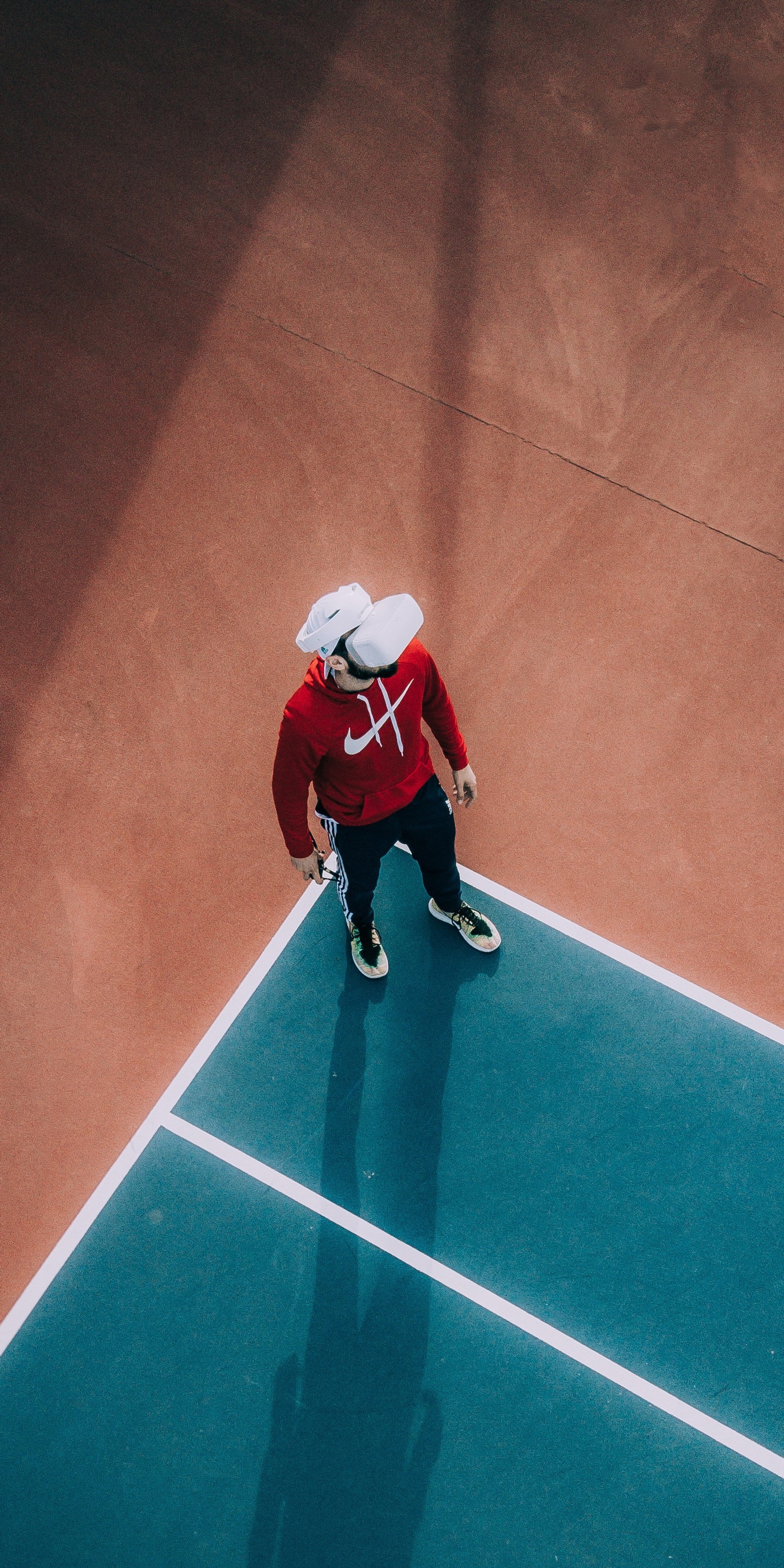 Hay un hombre de pie en una cancha de tenis sosteniendo una raqueta (realidad virtual, realidad aumentada, auriculares de realidad virtual, equipo deportivo, jugador)