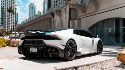 Eleganter weißer Lamborghini Huracán parkt vor einer modernen städtischen Kulisse und zeigt sein aerodynamisches Design und auffällige Merkmale.