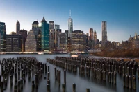 Horizon crépusculaire de New York avec réflexions et pilotis de quai