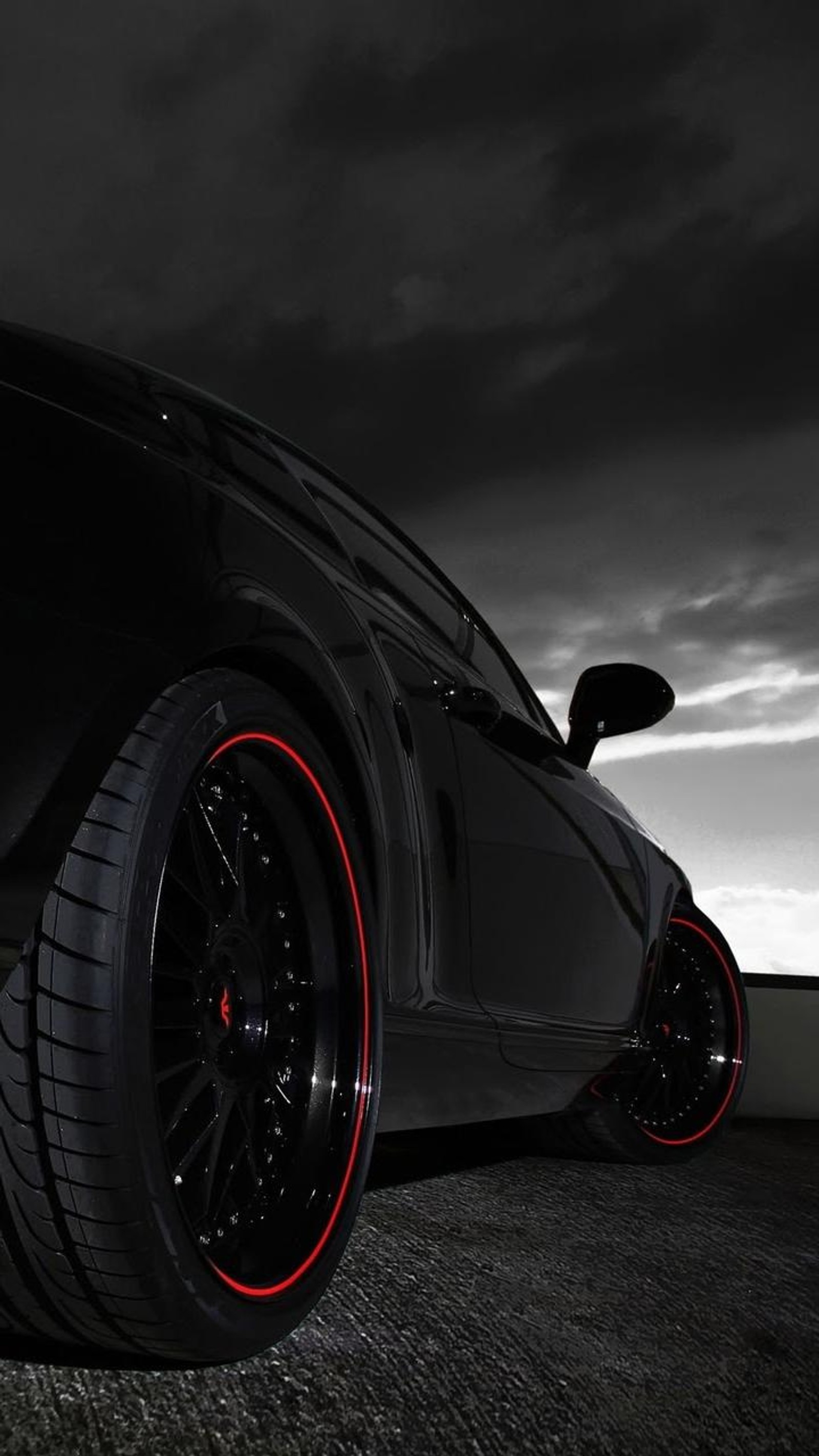 A close up of a black sports car with red rims (black, car, cars, sky)