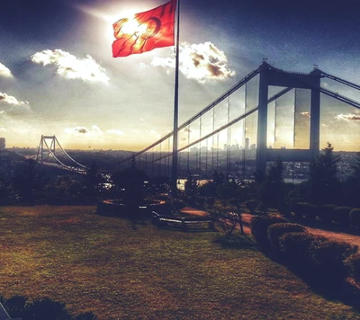 Turkish Flag Flutters Against a Sunset Backdrop Near a Bridge.