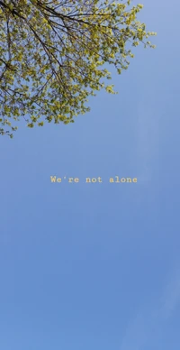 Aesthetic blue sky with tree branches and uplifting message: "We're not alone.