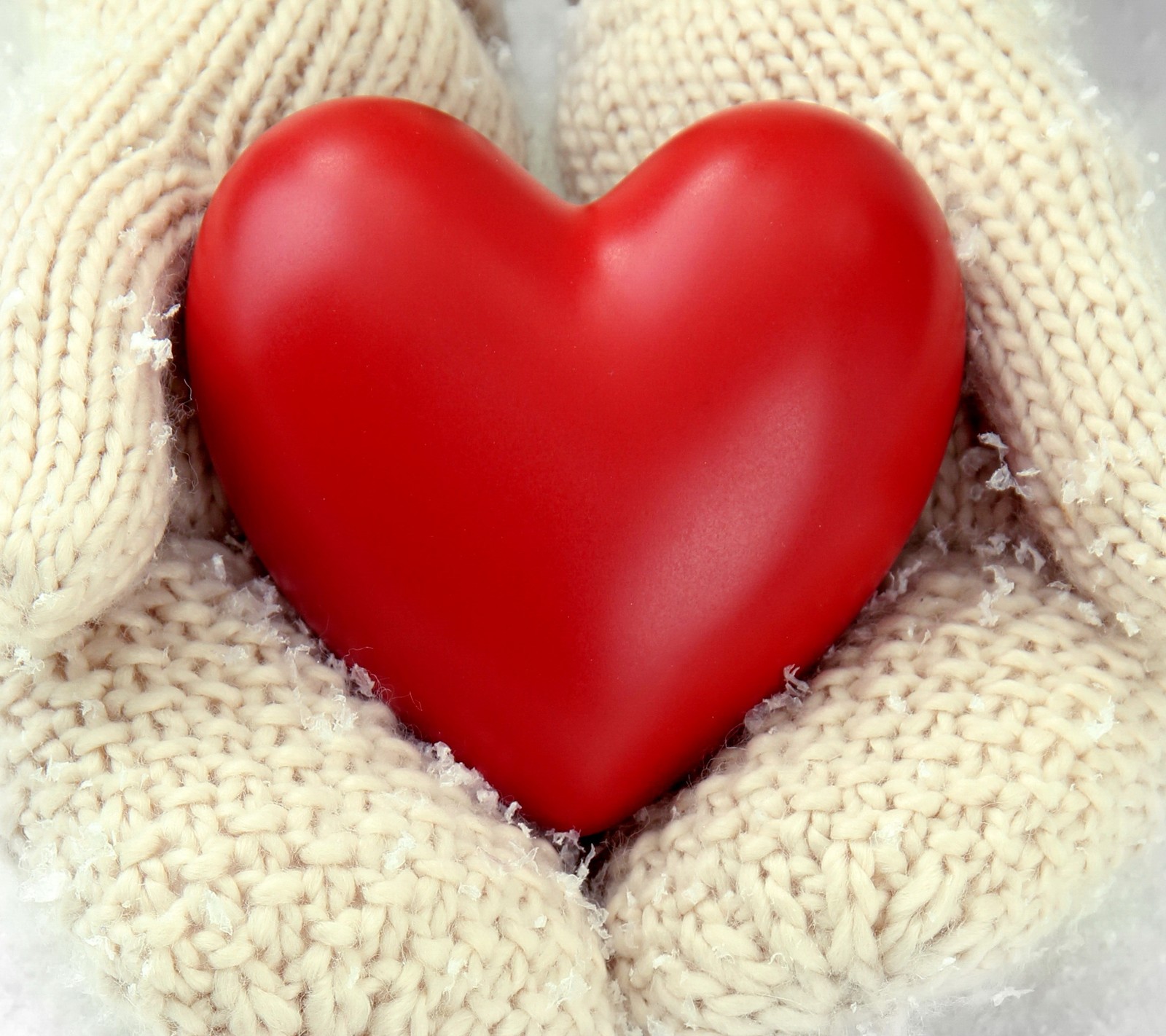 Someone holding a red heart in their hands in the snow (heart, love, romantic, valentine, winter)