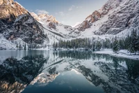 Lago Pragser: Montañas glaciares cubiertas de nieve reflejándose en un lago espejo