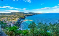 Deslumbrante vista costeira de Sorrento, exibindo a vibrante baía, a vegetação exuberante e a dramática paisagem montanhosa ao longo da costa.