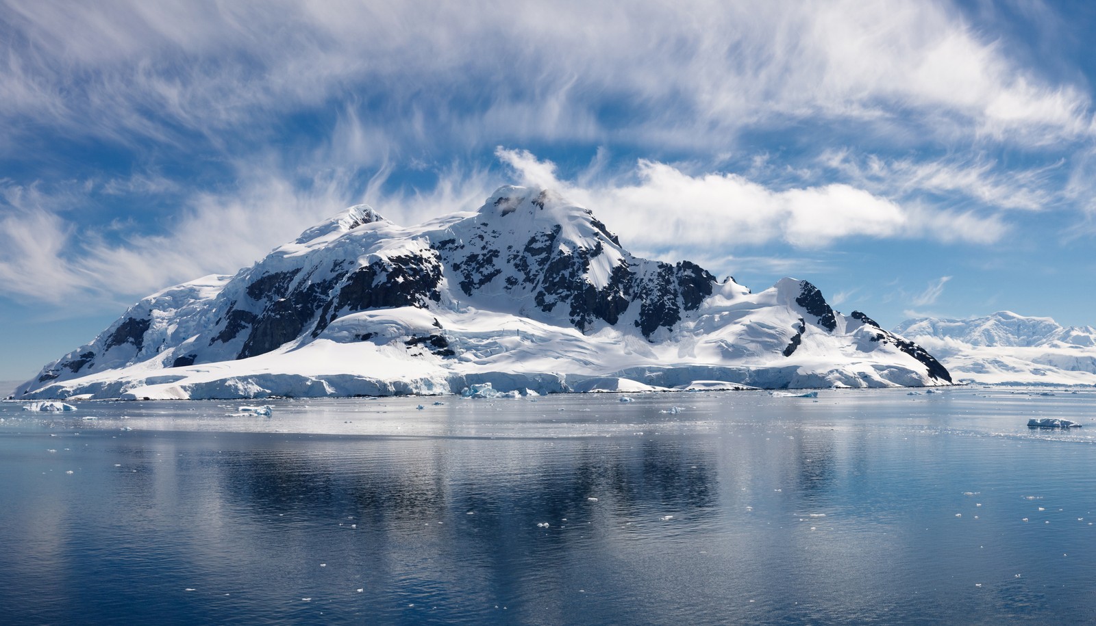 Una vista de una montaña con nieve en la cima (nieve, mar, isla, montaña, casquete polar)