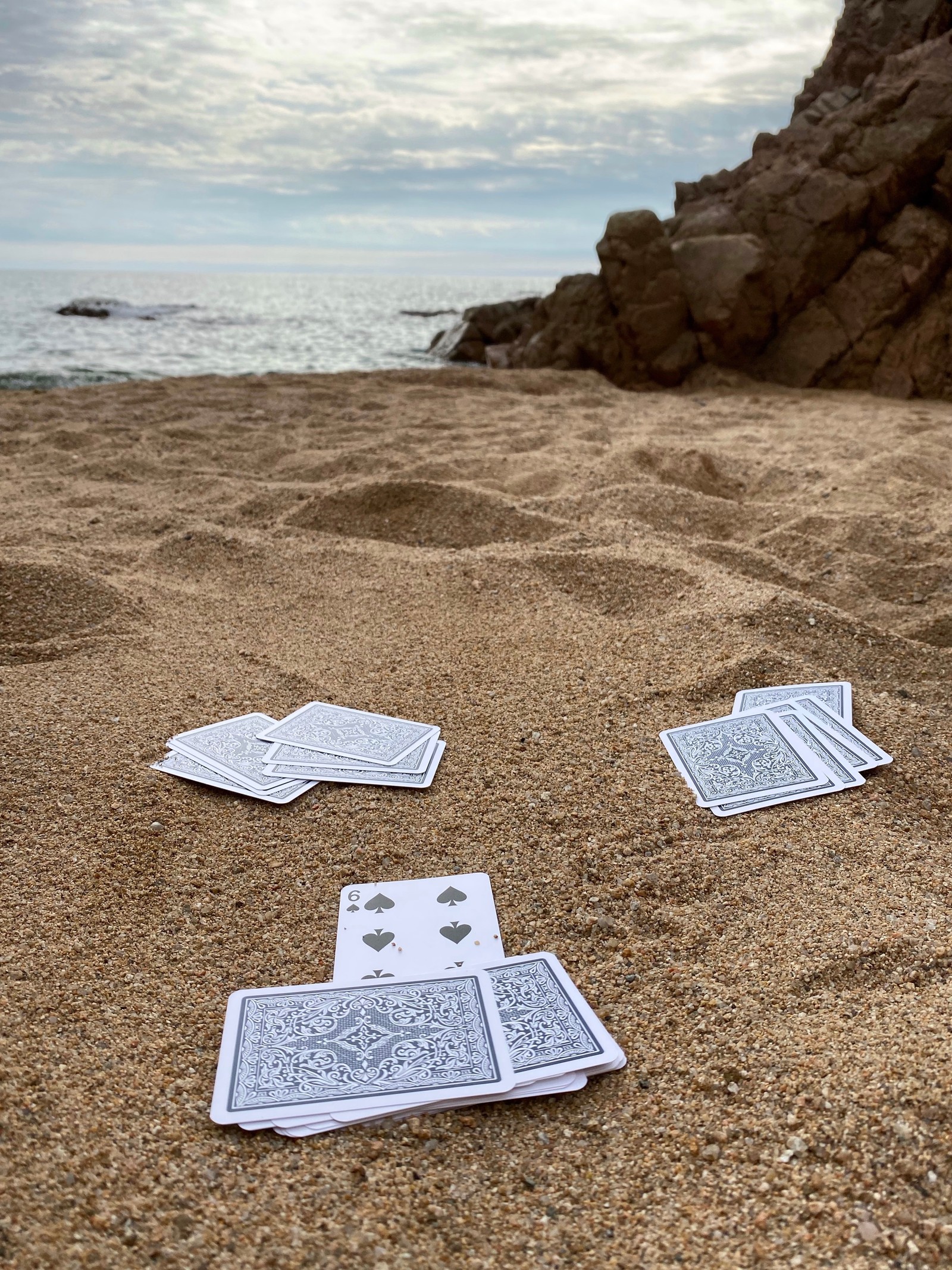 Várias cartas estão espalhadas na areia perto do oceano (mar, água, areia, terreno, geologia)