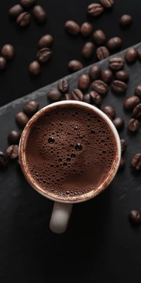 Café riche dans une tasse entourée de grains de café