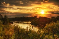 Goldene Morgenröte über einer ruhigen Flusslandschaft