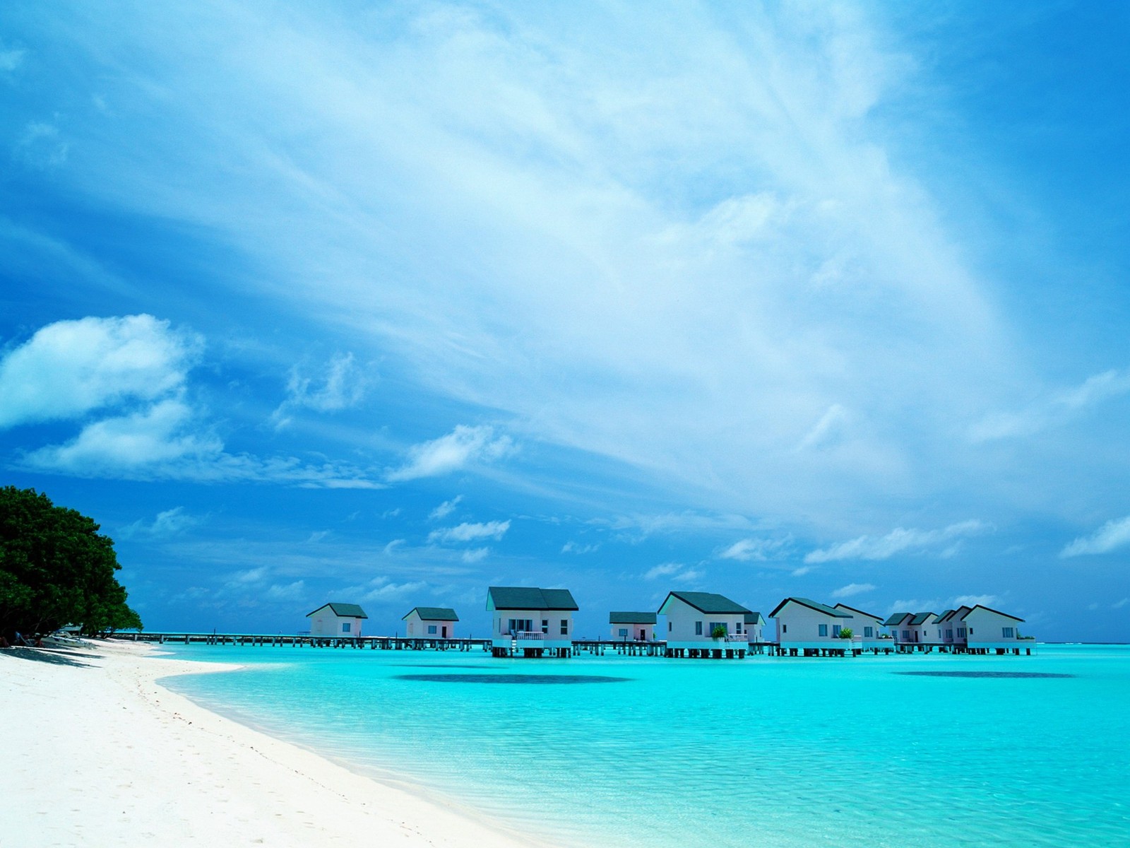 Há muitas casas na praia com água clara e azul (mar, oceano, trópicos, caribenho, formas costeiras e oceânicas)