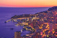 Paisagem urbana de Monte Carlo ao crepúsculo: Um pôr do sol deslumbrante sobre o porto