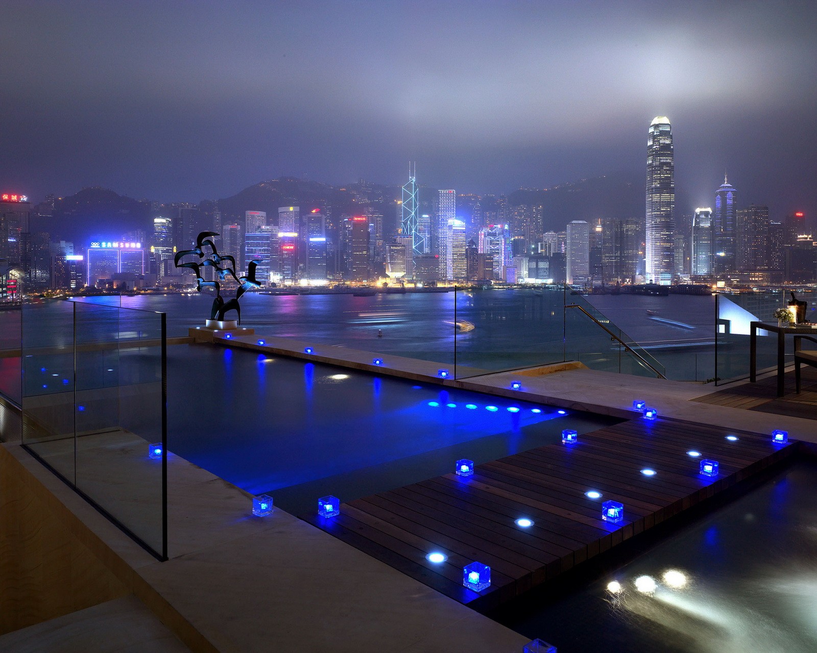 Vista nocturna de una piscina con vista al horizonte de la ciudad (edificios, ciudad, hd, luces, noche)