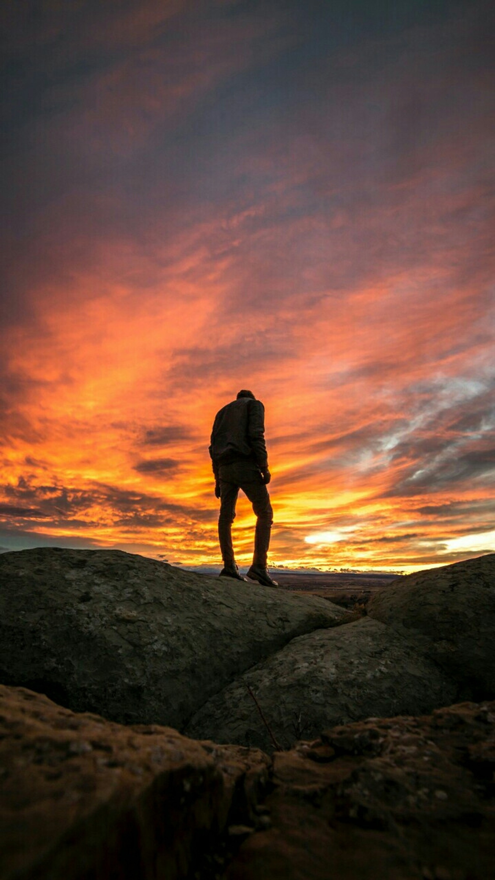 Arafed man standing on a rock with a backpack on his back (man, men)