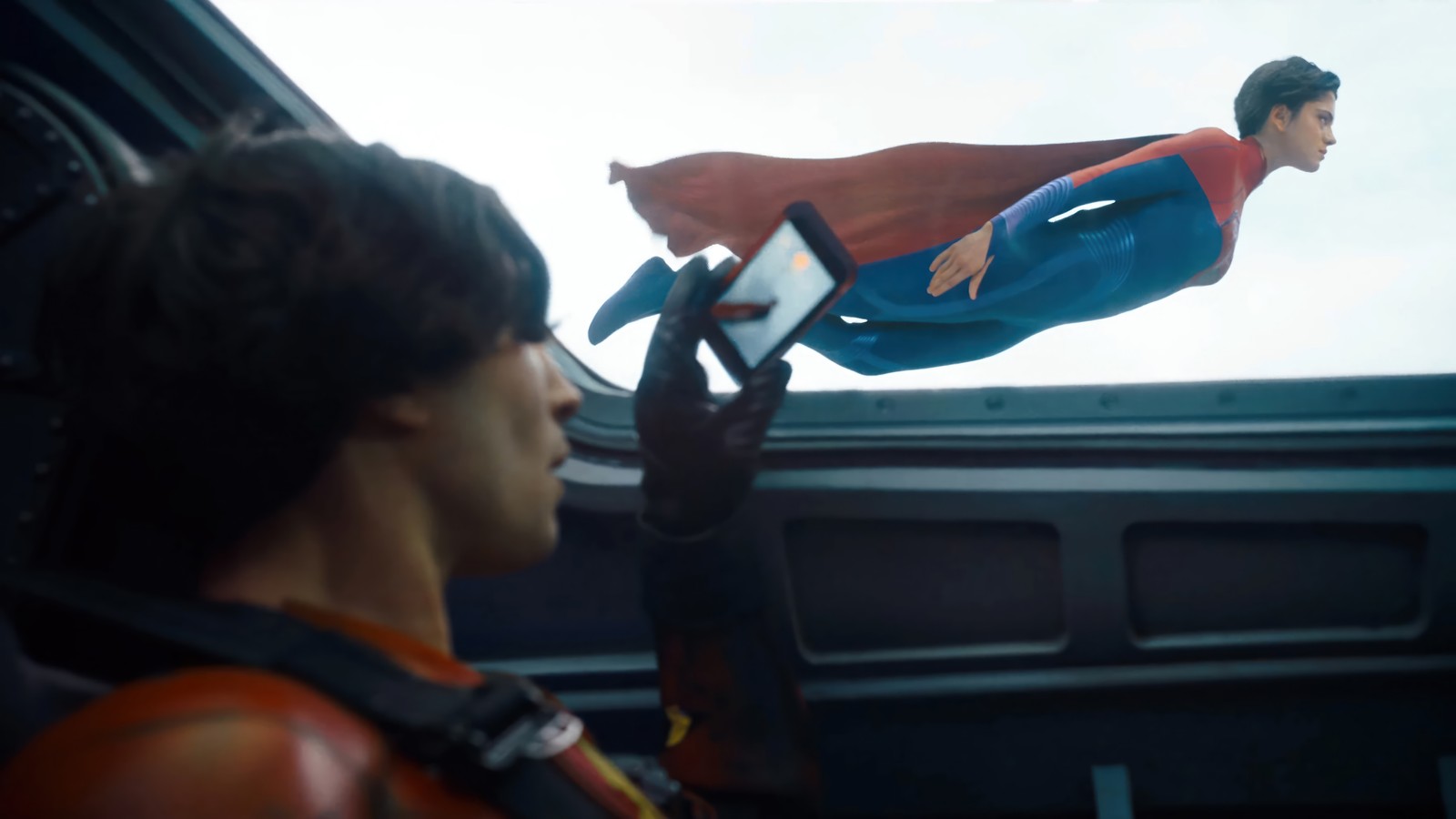 Arafed man flying through the air with a cell phone in his hand (the flash 2023, movie, dc, supergirl)