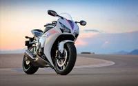 Honda CBR1000RR on a racetrack at sunset, showcasing its sleek design and performance capabilities.