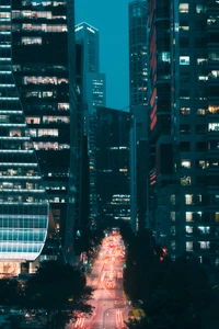 Vibrant cityscape showcasing a bustling metropolis at night, framed by towering skyscrapers and illuminated streets.