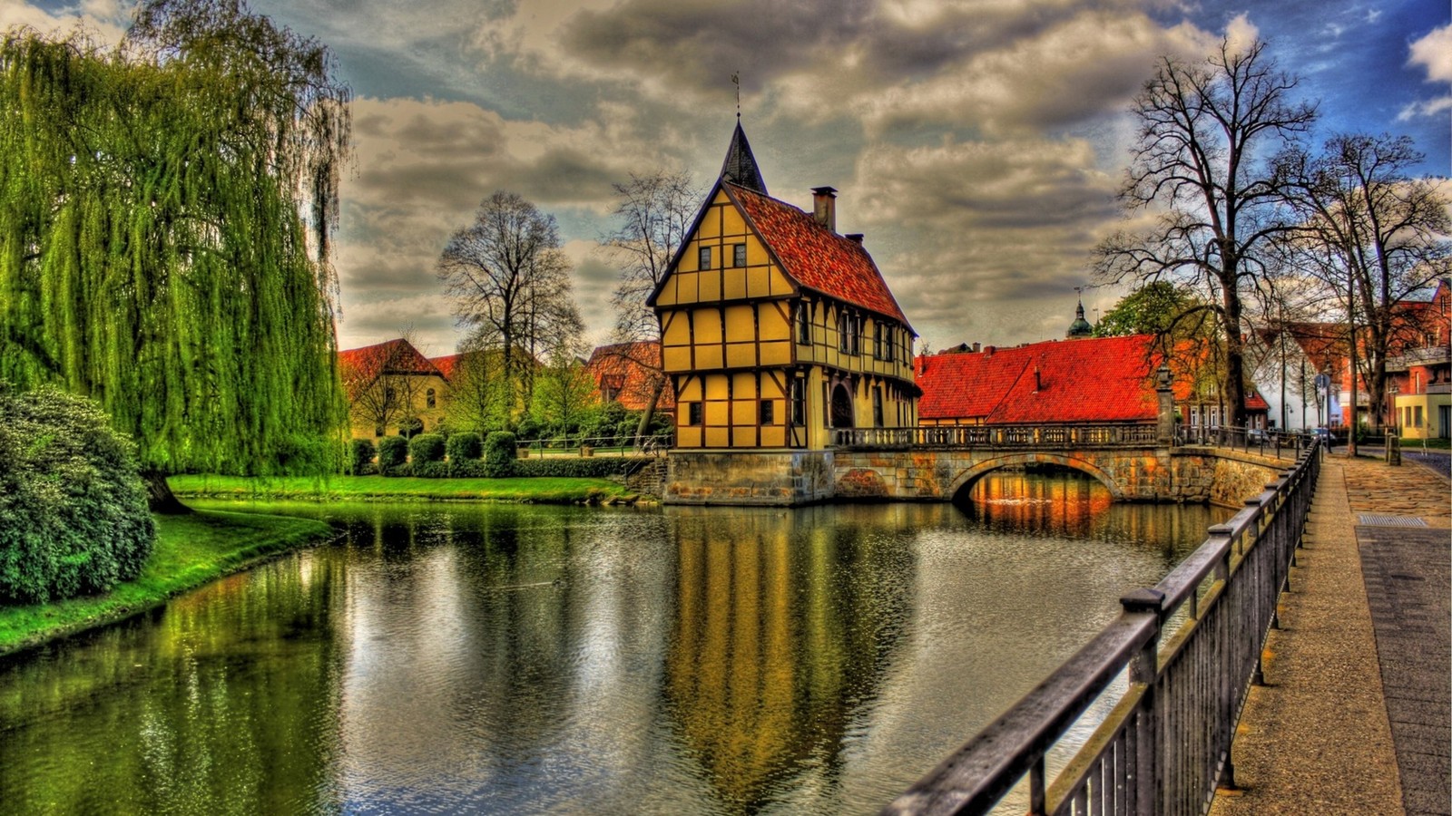 Un bâtiment pourri avec un toit rouge et un pont sur une rivière (voie navigable, nature, réflexion, point de repère, canal)