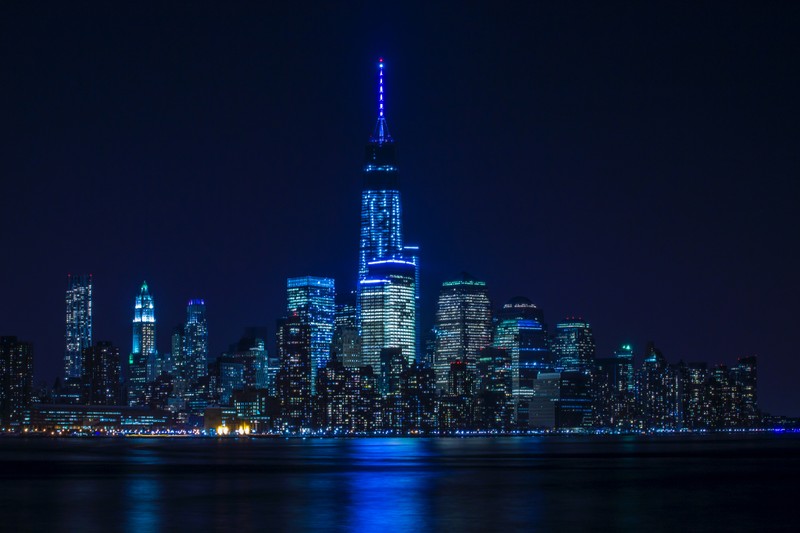 Аэрофотосъемка города ночью с ярким синим светом (нью йорк, new york city, городской горизонт, городской пейзаж, огни города)