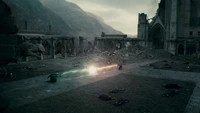 Duelo épico entre Harry Potter y Lord Voldemort en un paisaje desolado y marcado por la batalla.