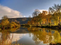 Reflexiones de otoño en una serena orilla del río