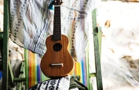 Ukelele descansando en una silla de playa entre telas coloridas