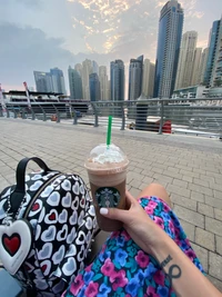 Relaxing by the waterfront in Dubai, enjoying a coffee with a view of the skyline.