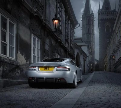 Aston Martin DBS aparcado en una calle histórica de Londres, enmarcado por arquitectura gótica.