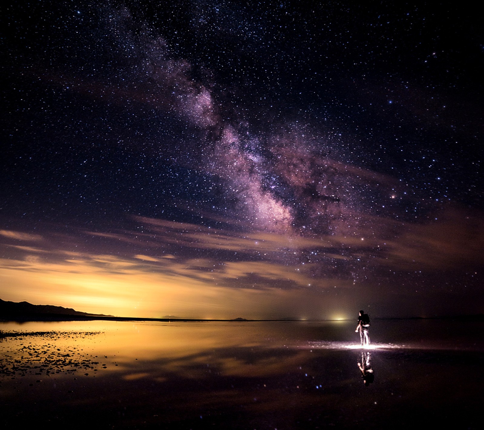 Imagem arafed de um homem em pé em uma praia sob um céu estrelado (noite, céu, estrelado)