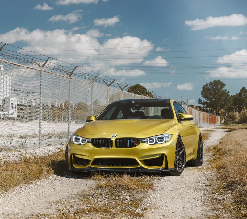 Ближний план желтой машины bmw, припаркованной на грунтовой дороге (bmw, машина, золото)