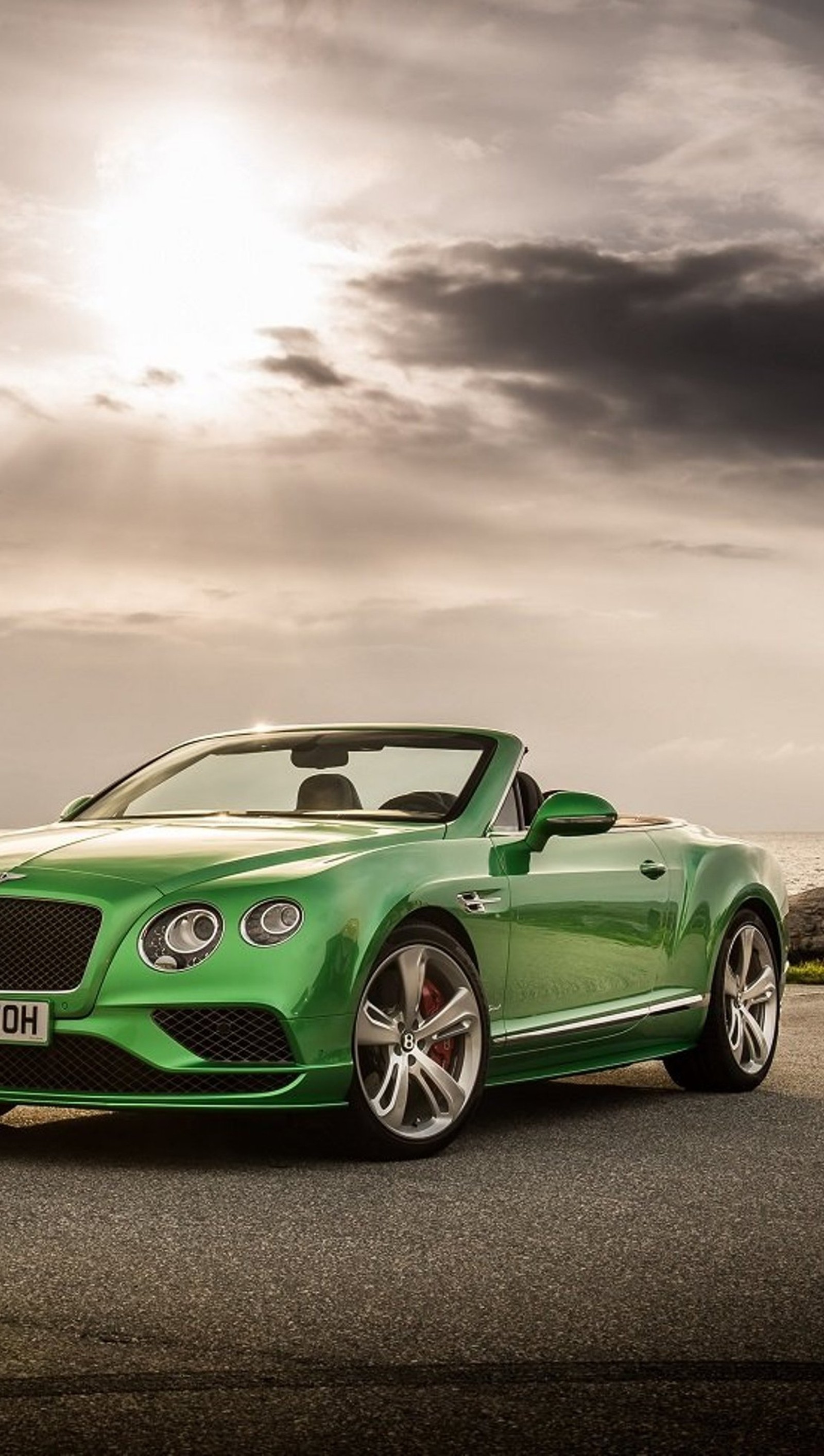 A close up of a green bentley convertible parked on a road (bentley, car, green, new)