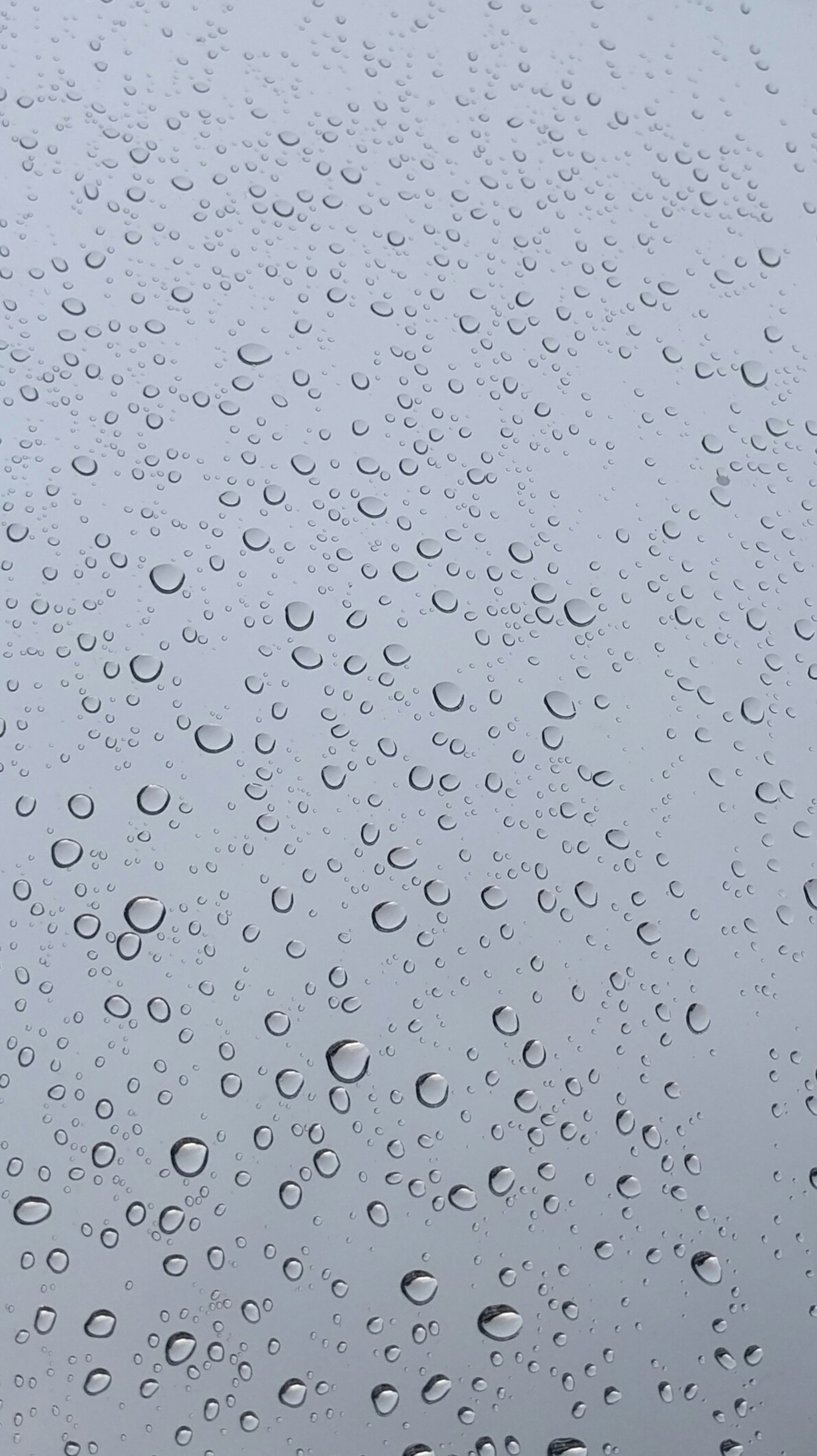 Un primer plano de una ventana cubierta de lluvia con gotas de agua (lluvia, ventana)