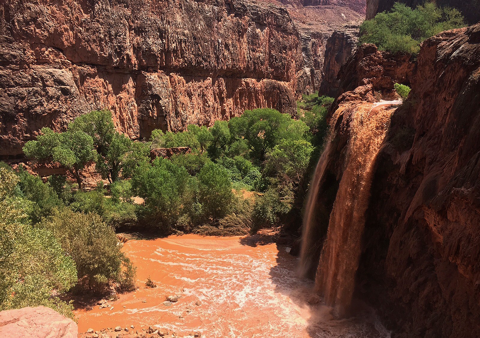 Vista arqueada de uma cachoeira em um cânion com um rio vermelho correndo através dele (grand canyon, cânion, cachoeira, natureza, wadi)