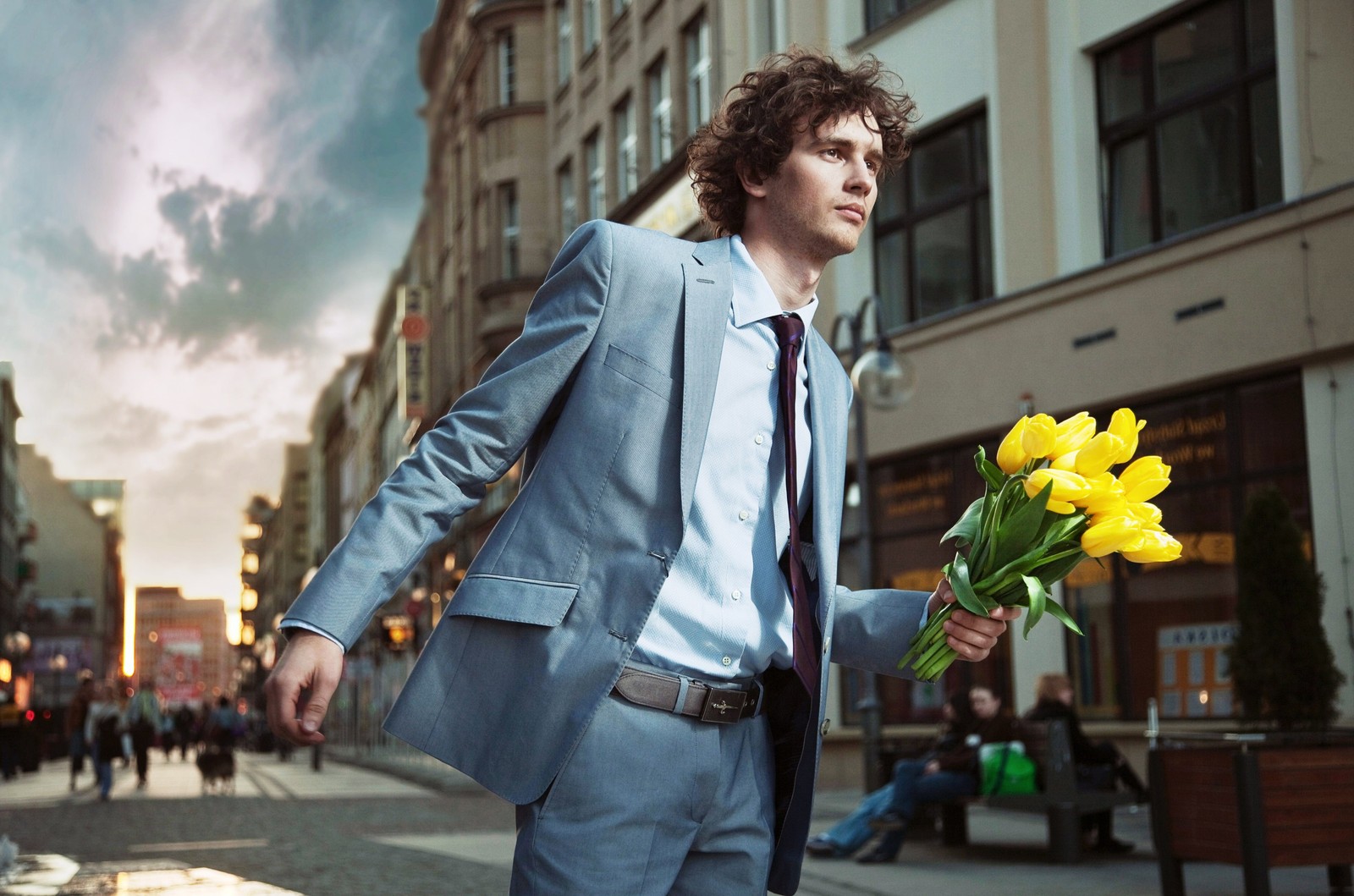 Un homme en costume et cravate tenant un bouquet de fleurs (mode, jeans, rencontres, blazer, denim)