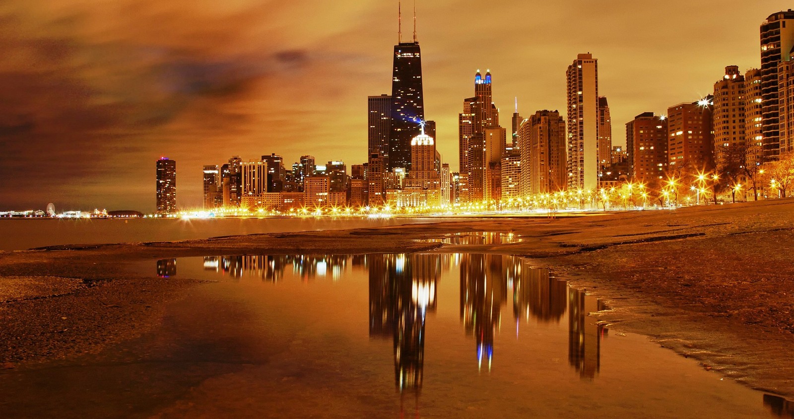 Vista aérea de un horizonte urbano de noche con un cuerpo de agua (chicago, paisaje urbano, ciudad, panorama, reflexión)