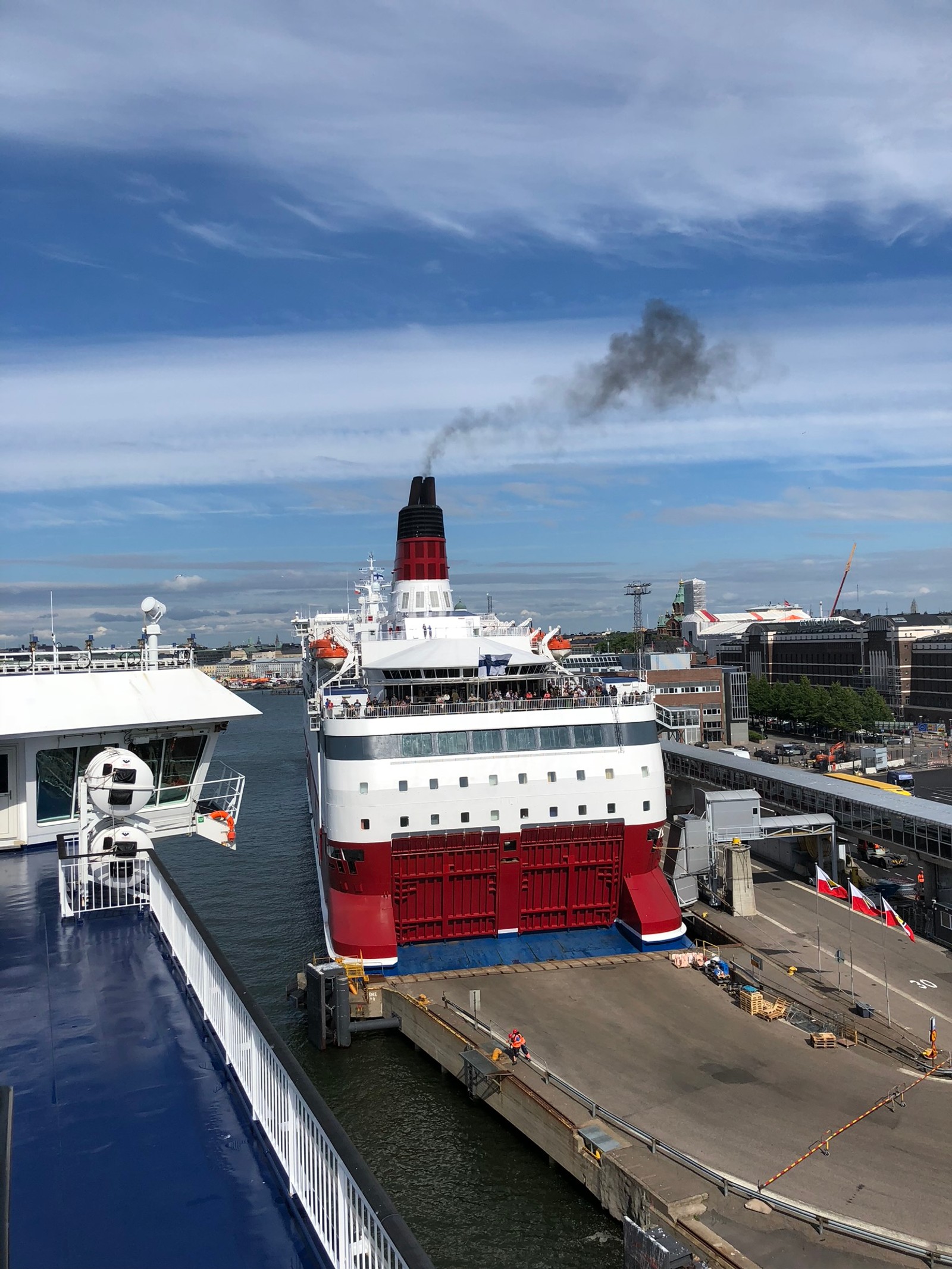 Um veleiro ancorado em um porto com um grande barco ao fundo (transporte aquático, ferry, navio de cruzeiro, navio de motor, arquitetura naval)