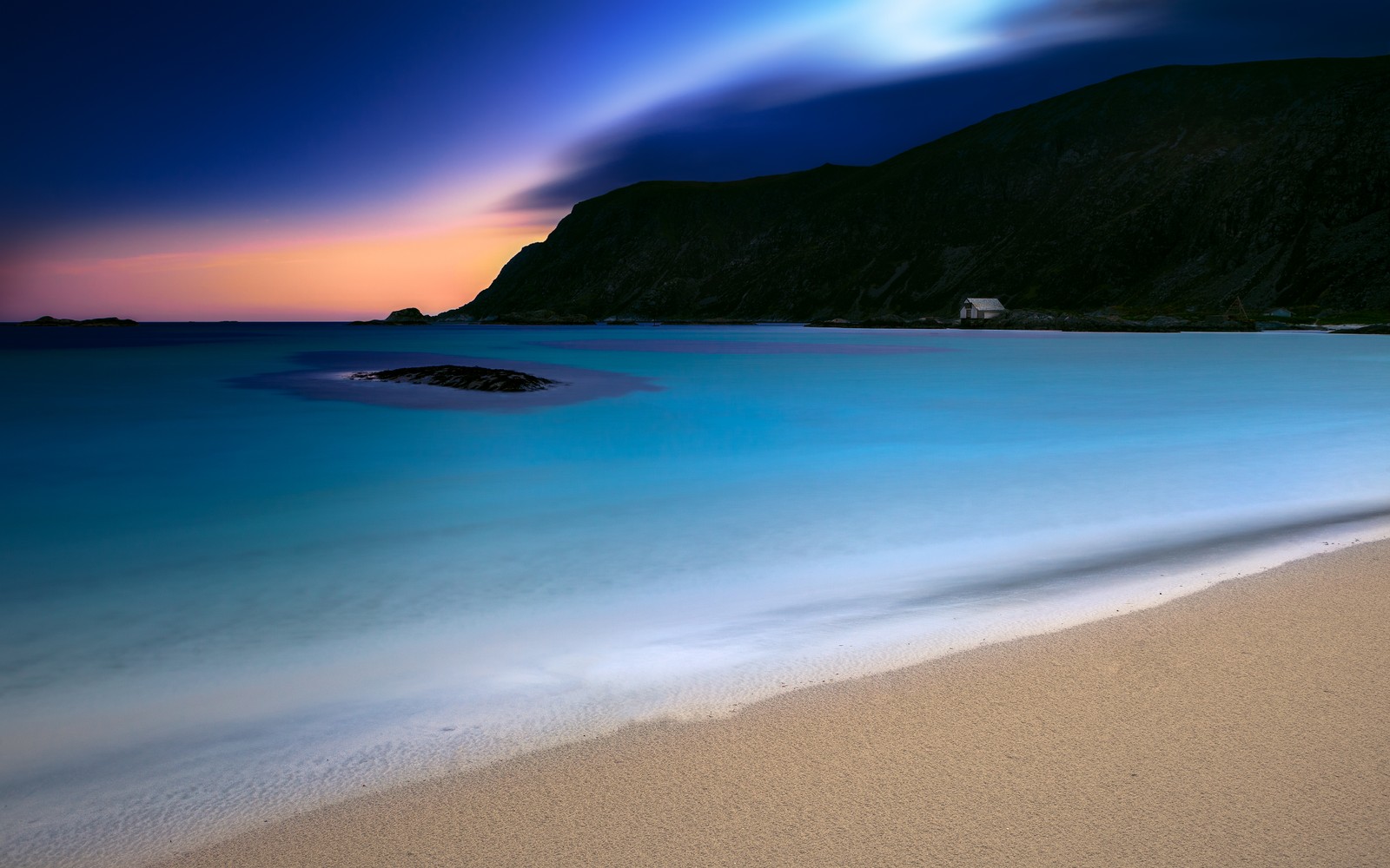 Vista de una playa con una montaña de fondo (playa de grotlesanden, grotlesanden beach, atardecer, noruega, costero)