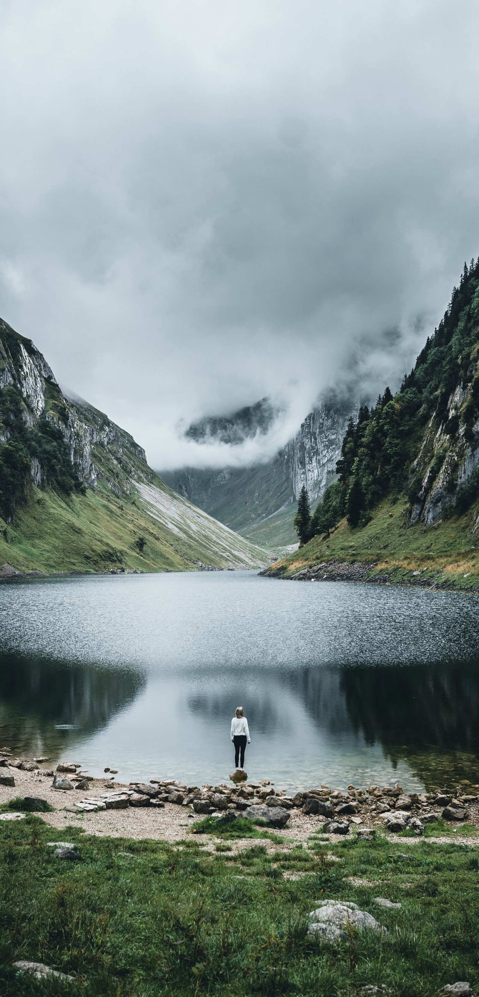 Uma pessoa em pé em uma rocha na frente de um lago (natureza, alpes, montanha, lago, wild)