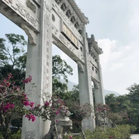 Monumento histórico de tallado en piedra rodeado de arbustos de primavera en el jardín