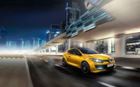 Hatchback jaune Renault en mouvement contre un paysage urbain nocturne