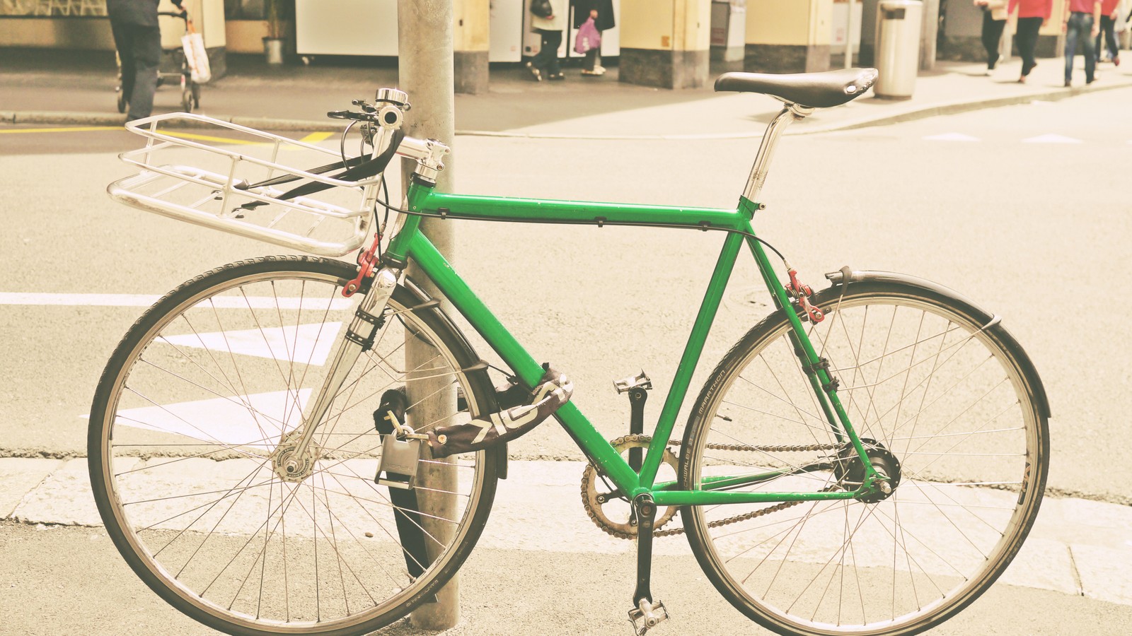 Uma bicicleta verde estacionada ao lado da rua (bicicleta, rua)