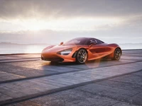 Sleek McLaren 720S en naranja vibrante contra un sereno fondo de atardecer