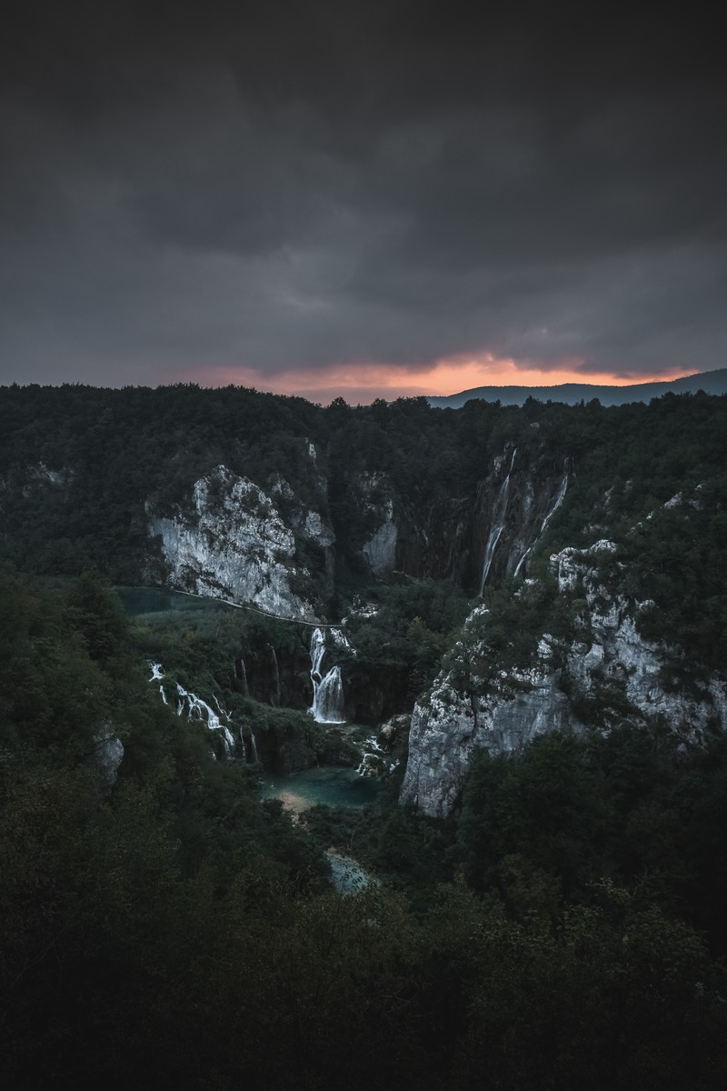 Uma vista de uma cachoeira com um céu escuro ao fundo (natureza, preto, céu, wild, atmosfera)