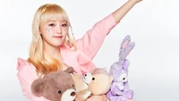 Yena from IZONE joyfully poses with plush toys, showcasing a whimsical and playful spirit from her "Oneiric Diary" album.