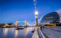 Puente de la Torre y Ayuntamiento iluminados al anochecer en Londres