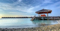 Coucher de soleil tranquille sur un pavillon en bord de mer aux Maldives