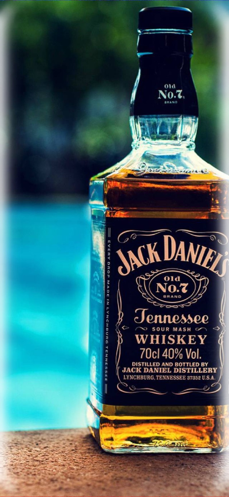 Близкий план бутылки виски jack daniels, стоящей на краю (samsung, галактика, s10, заметка, 10)