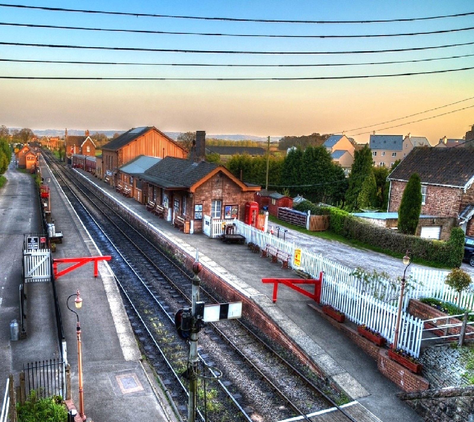 Hay una estación de tren con un tren en las vías (naturaleza)