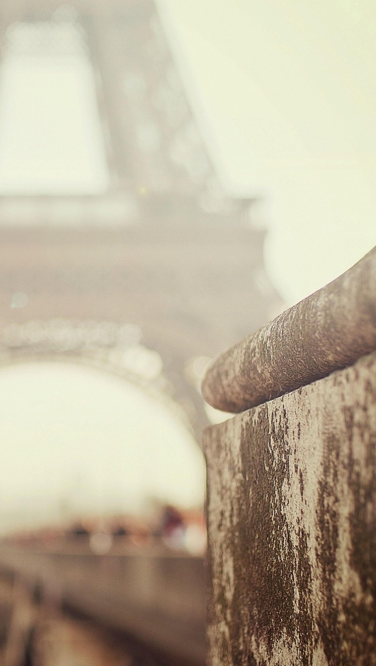 There is a close up of a wall with a tower in the background (eifel tower, grey, paris)